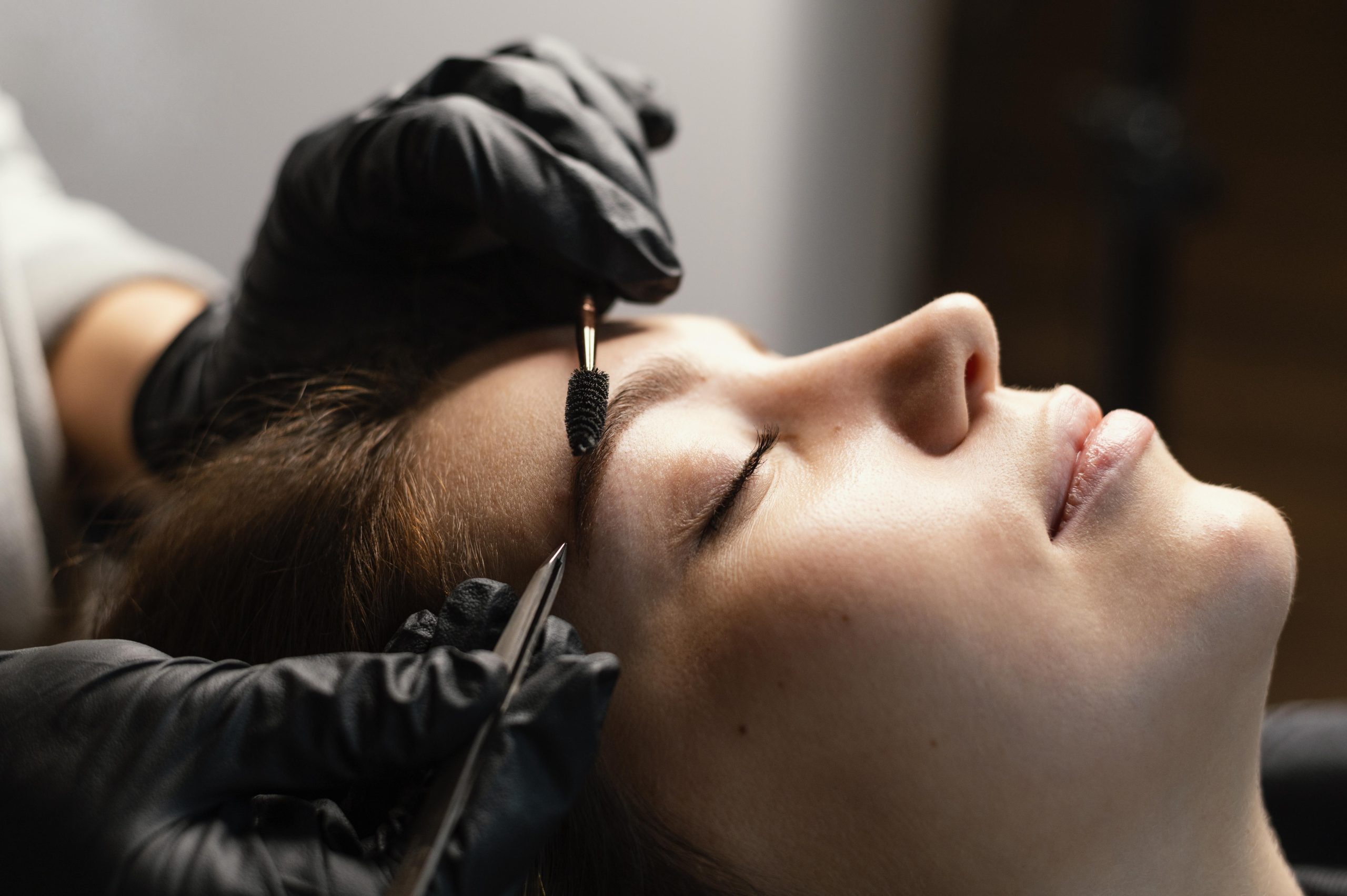 side-view-of-female-specialist-doing-an-eyebrow-treatment-for-woman